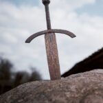 A rusty sword in a stone, an iconic metaphor for the "chosen one" trope in fantasy fiction.