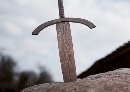 A rusty sword in a stone, an iconic metaphor for the "chosen one" trope in fantasy fiction.