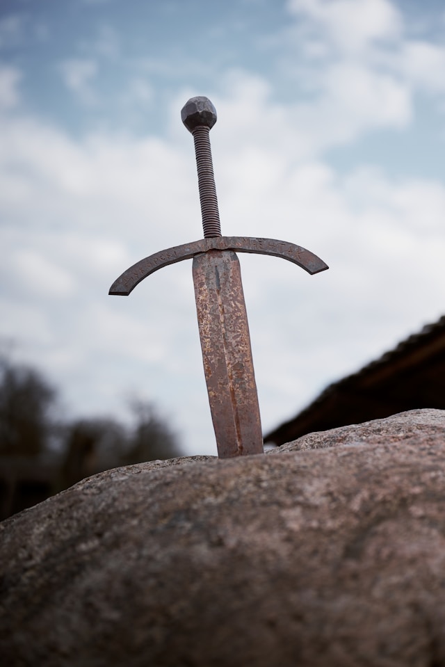 A rusty sword in a stone, an iconic metaphor for the "chosen one" trope in fantasy fiction.