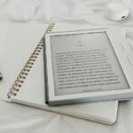 A Kobo e-reader with the first page of Moby Dick displayed rests atop an open paper notebook. Ever wonder what Herman Melville might have earned in audiobook royalties?