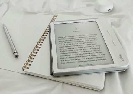 A Kobo e-reader with the first page of Moby Dick displayed rests atop an open paper notebook. Ever wonder what Herman Melville might have earned in audiobook royalties?