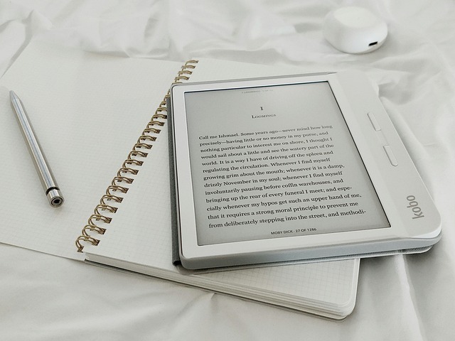 A Kobo e-reader with the first page of Moby Dick displayed rests atop an open paper notebook. Ever wonder what Herman Melville might have earned in audiobook royalties?