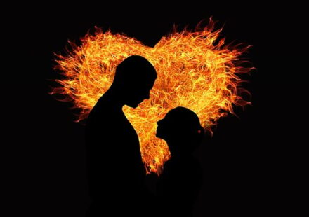 The silhouettes of a man and a woman backlit by a fiery heart. This depicts slow burn romance at its best!